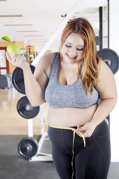 Mujer obesa con cinta métrica y manzana — Foto de Stock