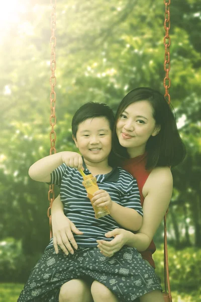 Mãe e filho sentados no balanço — Fotografia de Stock