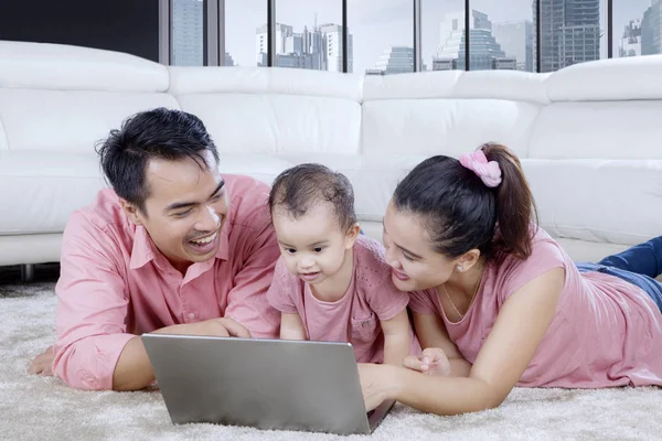 Pequeno bebê e seus pais usando um laptop — Fotografia de Stock