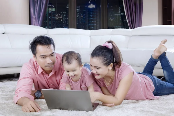 Gelukkige ouders met behulp van een laptop met kind — Stockfoto