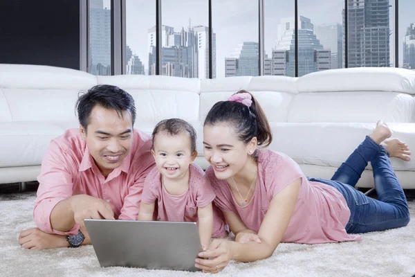 Lycklig familj njuter av fritid med en bärbar dator — Stockfoto