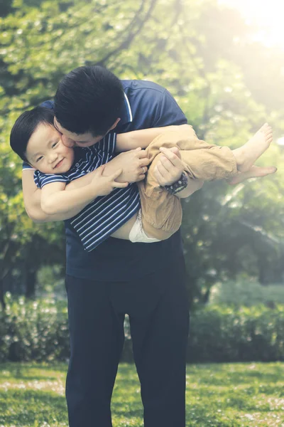 Отец целует сына в парке. — стоковое фото