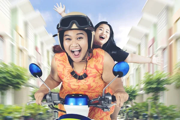 Mujeres gordas montando una motocicleta en la calle residencial —  Fotos de Stock