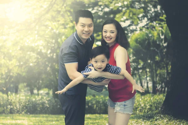 Família chinesa balançando seu filho — Fotografia de Stock