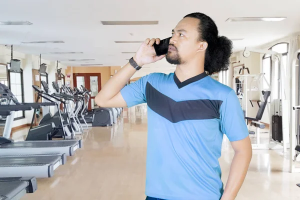 African man with smartphone in gym center