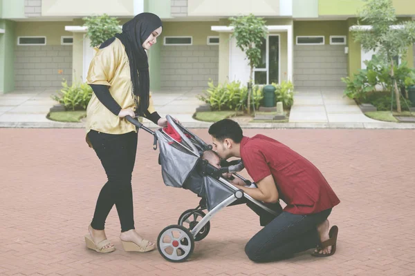 Familia musulmana besando a su bebé en el cochecito —  Fotos de Stock