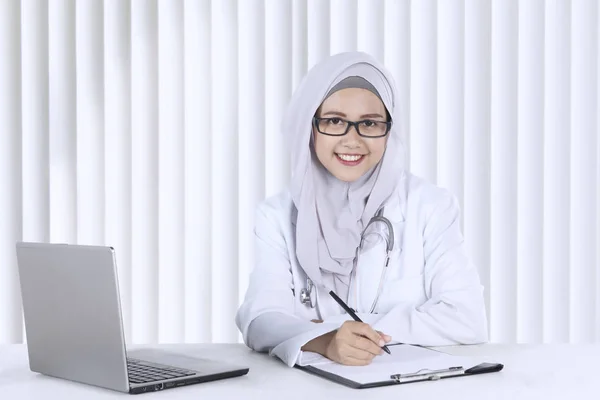 Médico musulmán trabajando con portapapeles — Foto de Stock