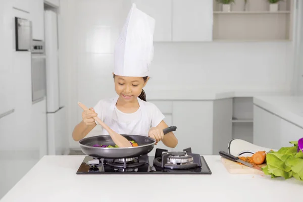 Kleines Mädchen kocht gesunde Mahlzeit in der Küche — Stockfoto