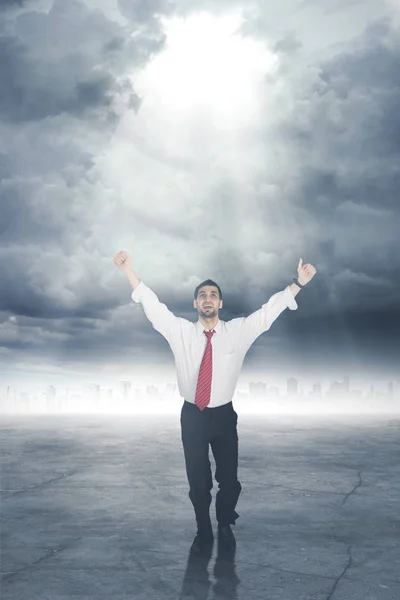 Feliz hombre de negocios de pie bajo una luz brillante — Foto de Stock