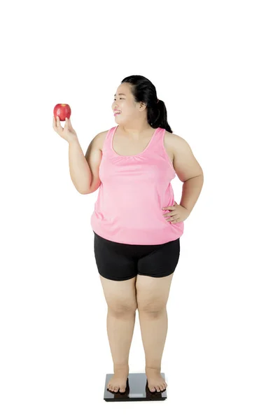 Mujer gorda con manzana y báscula de pesaje — Foto de Stock