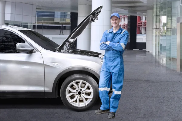 Mecánico europeo de pie cerca de un coche roto —  Fotos de Stock