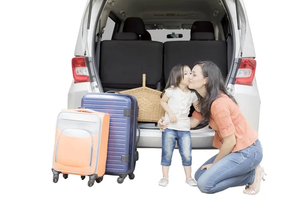 Niña besando a su madre cerca de su coche — Foto de Stock