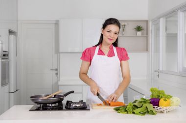 Mutlu kadın mutfakta bir havuç Dilimleme