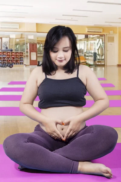 Mulher grávida fazendo um símbolo do coração — Fotografia de Stock