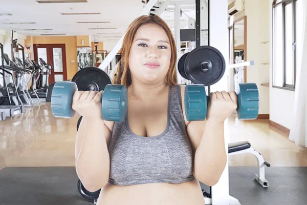 Mulher com excesso de peso fazendo um treino com halteres — Fotografia de Stock