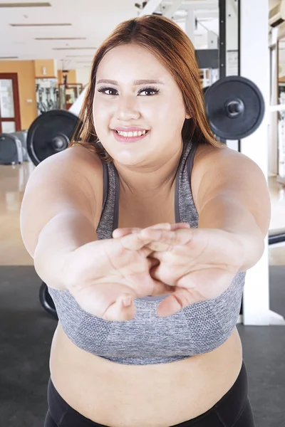 Feta kvinnan stretching i stadens gym — Stockfoto