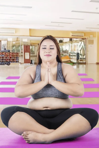 Obese girl practicing yoga in the fitness center — Stock Photo, Image