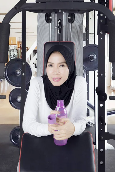 Muslimsk kvinna med flaska i gymmet — Stockfoto