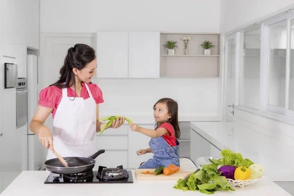 Küçük kız annesi mutfakta yemek yardım — Stok fotoğraf