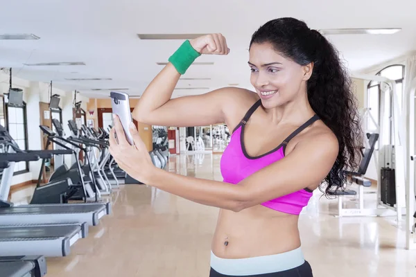 Indian woman taking photo her arm muscle — Stock Photo, Image