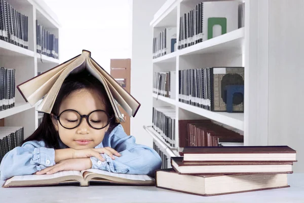 Έξυπνο κορίτσι διαβάζοντας ένα βιβλίο στη βιβλιοθήκη — Φωτογραφία Αρχείου