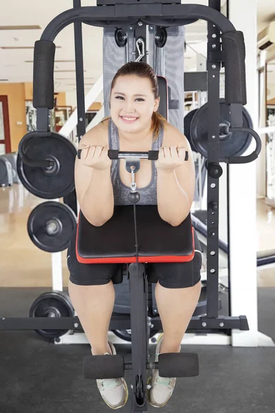 Caucasian obese woman exercising her biceps