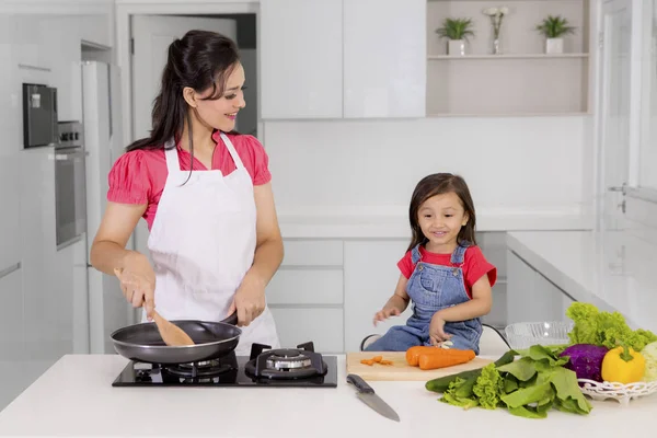 Mulher bonita com criança cozinhar juntos — Fotografia de Stock