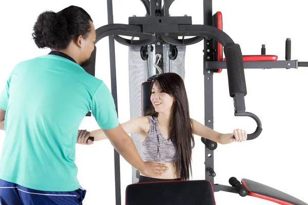 Trainer en meisje met gewicht machine op studio — Stockfoto