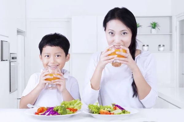 Ung mamma och son dricka juice — Stockfoto