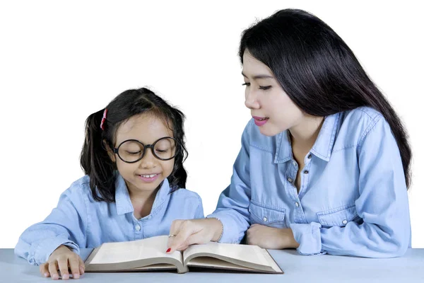 Lehrerin führt ihre Schülerin zum Lesen — Stockfoto