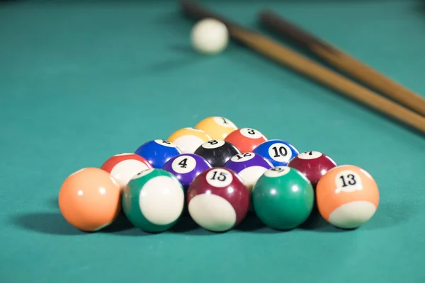 Palos y bolas de billar en la mesa de billar — Foto de Stock