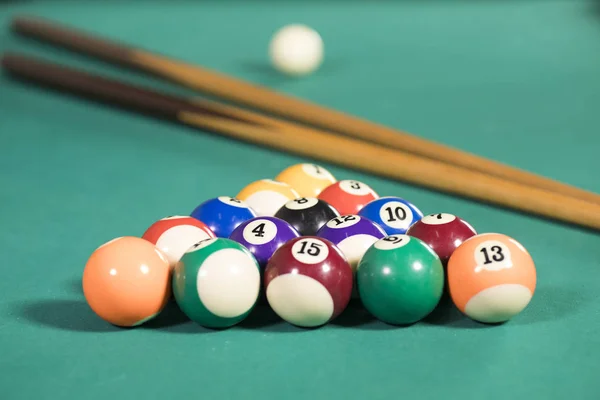 Bolas de bilhar e paus na mesa de bilhar — Fotografia de Stock