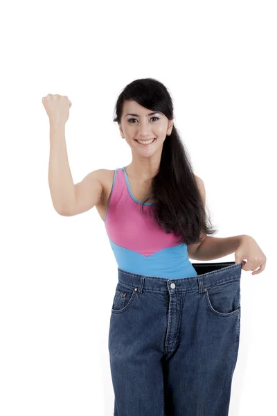 Beautiful Asian woman showing her weight loss isolated over white — Stock Photo, Image