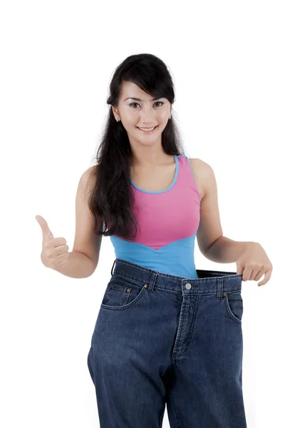 Asian woman showing her weight loss isolated over white — Stock Photo, Image