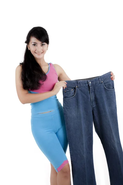 Mulher de emagrecimento segurando um jeans de grandes dimensões — Fotografia de Stock