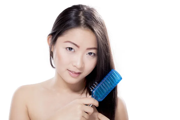 Cute Asian woman with long hair brushing hair — Stock Photo, Image