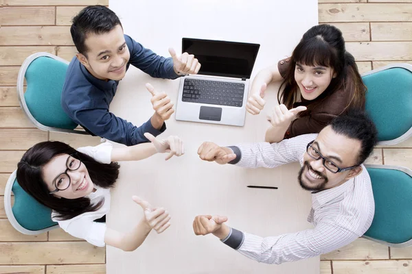 Foto de alto ângulo de empresários asiáticos mostrando polegares para cima em uma reunião — Fotografia de Stock