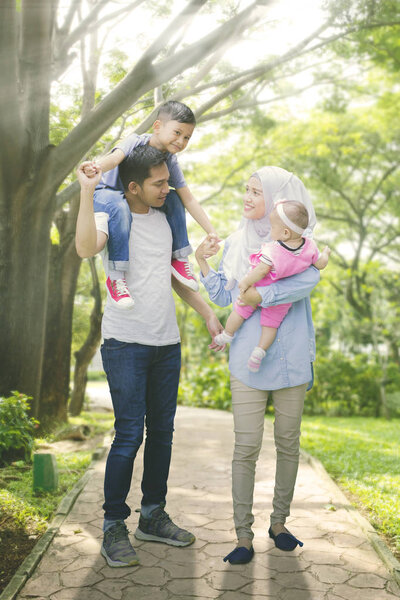 Средний снимок азиатской мусульманской семьи, хорошо проводящей время
