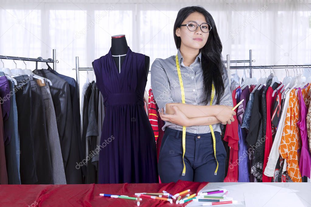 Confident Asian fashion designer keeping arms crossed