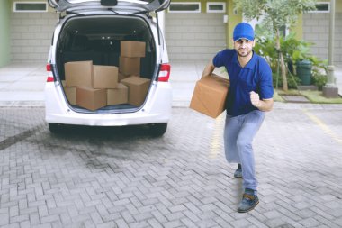 Genç teslimatçı önünde Van ile karton kutular