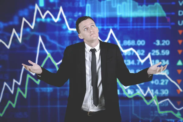 Confused caucasian businessman with declining business charts — Stock Photo, Image