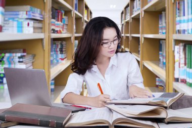 Güzel kız öğrencinin okul Kitaplığı'nda yapıyor