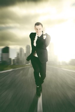 Businessman running on the road against cityscape background clipart