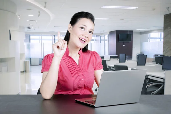 Ευτυχισμένη γυναίκα να πάρει μια ιδέα ενώ εργάζεστε στο φορητό υπολογιστή στο γραφείο — Φωτογραφία Αρχείου
