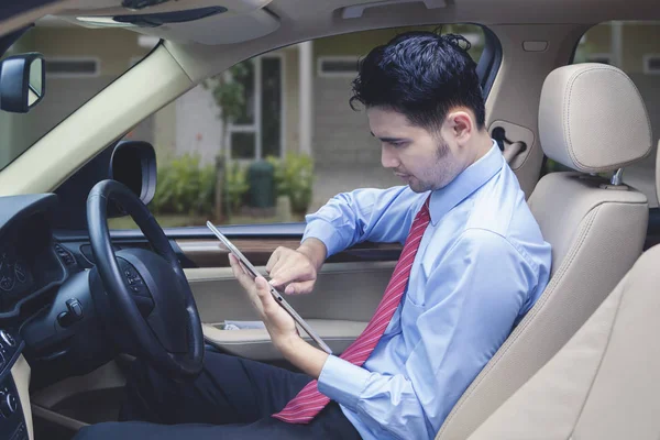 Человек за рулем проверяет цифровой планшет для определения местонахождения адреса — стоковое фото