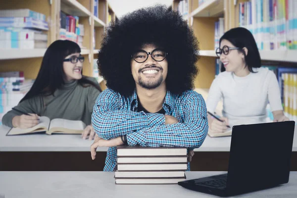 Studente afro con i suoi amici in biblioteca — Foto Stock