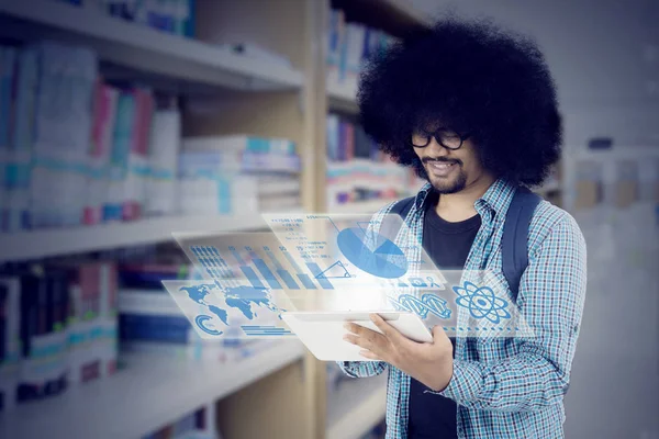 Afro student met behulp van Tablet PC in de bibliotheek — Stockfoto