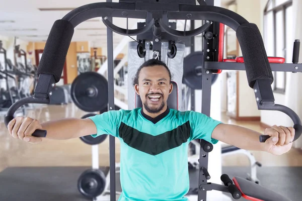 Happy asian man exercising in gym