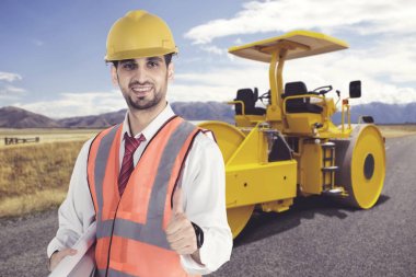 Erkek mühendis emniyet kask ayakta buharlı silindir önünde giyen yol şantiye Park