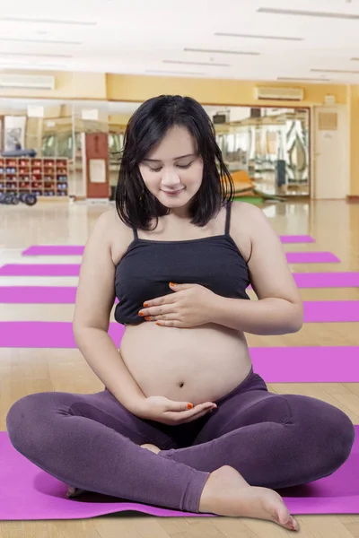 Werdende Mutter nach Morgengymnastik mit den Händen auf dem Bauch — Stockfoto